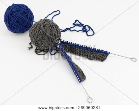 Blue And Gray Balls Of Wool With Knitting Needles On White Background