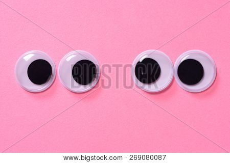Googly Eyes Of Pair Of Lovers On Rose Background. Close Up.