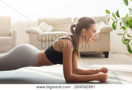 Workout. Side View At Young Woman Doing Plank, Exercising At Home