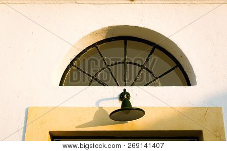 Home Porch Light At The Entrance Of The Cap De Artrutx Lighthouse, On The Island Of Menorca, Baleari