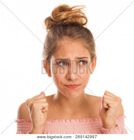Body language and emotions concept. Glad dark haired beautiful satisfied girl beggs God to help her, keeps fingers crossed, wishes good luck, prays indoor isolated over gray studio background.