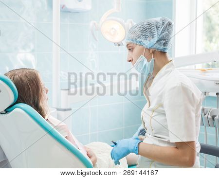 Girl Patient With Dentist And Assistant In A Dental Treatment