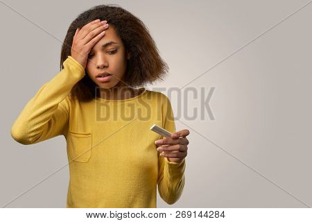 A Tired Black Woman Feels A Headache, Fatigue, Holds Her Hand On Her Head. Woman Looking At Test And