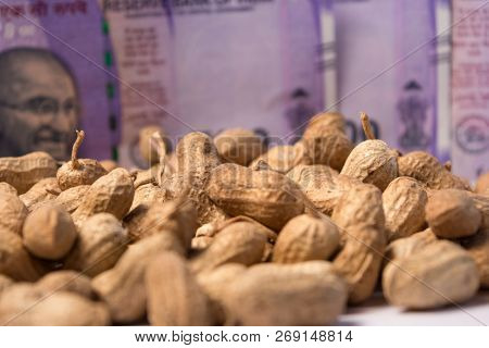 Close Up Of Peanuts Or Groundnuts With Indian Currency Notes Background