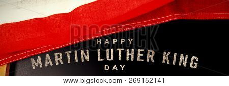 happy Martin Luther King day against american flag and empty slate on wooden table