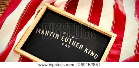 happy Martin Luther King day against american flag with slate on wooden table