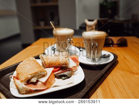 Breakfest Snack - Coffee Latte And Bocadillo Sandwich On Table In One Cafe