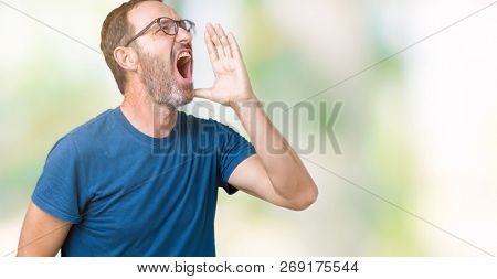 Handsome middle age hoary senior man wearin glasses over isolated background shouting and screaming loud to side with hand on mouth. Communication concept.