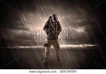 Terrorist in a stormy space with gas mask on his hand and weapons on his arm