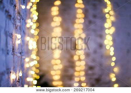 White Brike Wall With Blurred Background With Bokeh Lights, Electric Garland.