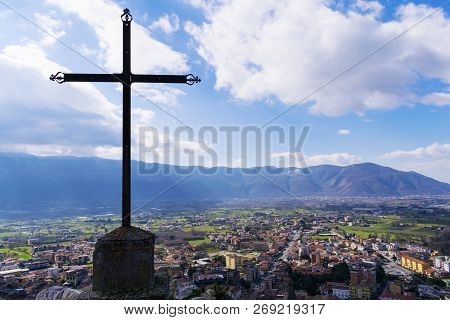 A Steel Christian Cross On Top Of A Mountain And A City Landscape. Beautiful Cityscape. Italy