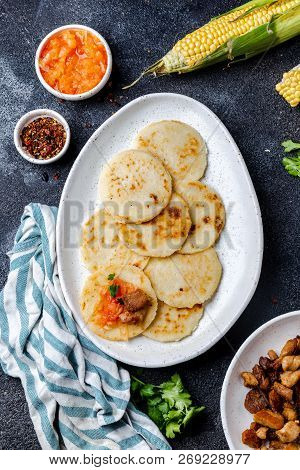 Colombian Food. Maize Arepas And Fried Pork Chicharron Ans Colombian Tomato Sauce. Top View. Black B