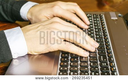 Hand Typing On Laptop Keyboard. Businessman Using A Laptop Computer.