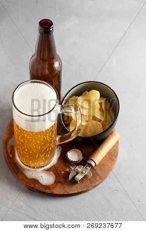 Lager Beer In Glass And Bottle With Potato Chips On Gray Concrete Background