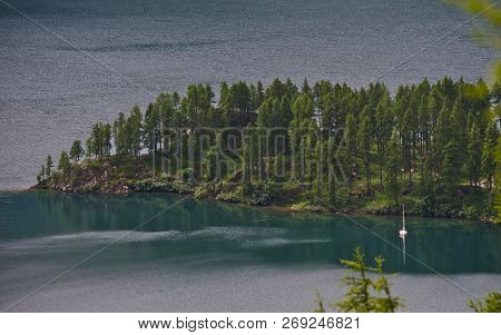 A Lone Sailboat In A Secluded Bay On An Alpine Lake