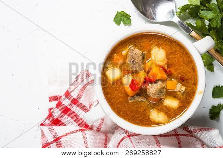 Traditional Hungarian Goulash Soup On White Stone Table. European Cuisine. Top View With Copy Space.