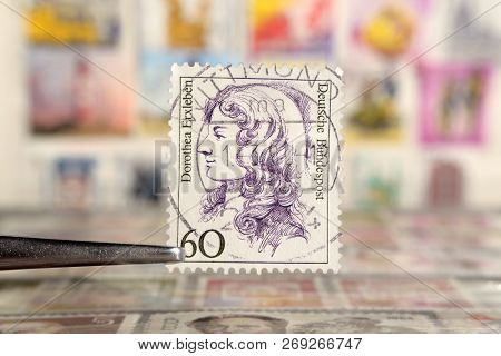 Kiev, Ukraine, November 17, 2018: Tweezer Holds Postage Stamp Of Germany, Shows Women In History Doc