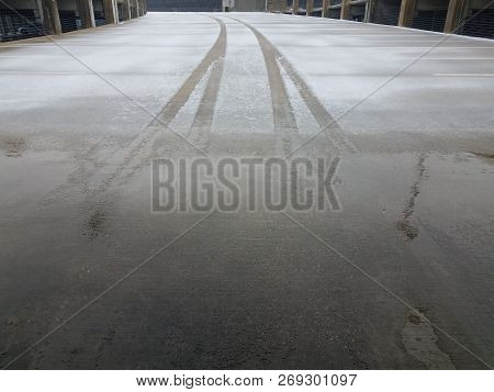 Tire Tracks In The Ice And Snow On Parking Structure