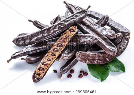 Carob pods and carob powder on the white background.