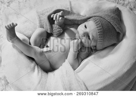 A Naked Newborn Baby Sleeps In A Christmas Hat.