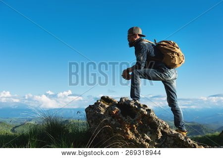 Stylish Bearded Male Traveler In Sunglasses And A Cap With A Backpack In A Denim Suit And Yellow Sho