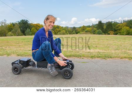 Dutch Woman Rides Electrical Mountainboard On Road In German Nature