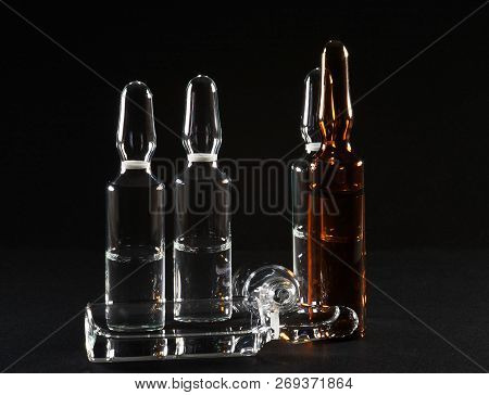 Row Of Ampulas With Medicine On Black Background