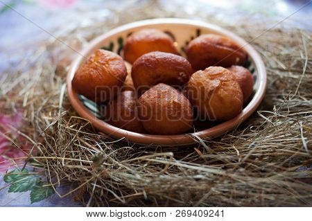 Ukrainian Donuts In A Decorative Bowl. Donuts On The Table Covered With Hay