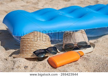 Sunhats, Sunglasses And Sunprotection Cream On The Sand Near The Blue Inflatable Matress , Illustrat