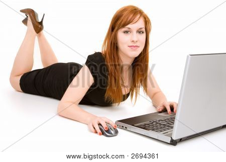 Młode Rude kobiety leżącej przy użyciu laptopa