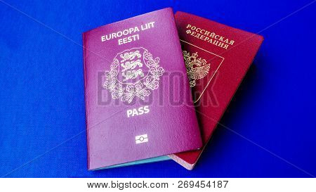 Passports On The Blue Background. Citizenship Of Estonia And Russia. Citizenship Of European Union (
