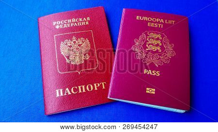 Passports On The Blue Background. Citizenship Of Estonia And Russia. Citizenship Of European Union (