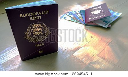 Passports On The Wooden Background. Citizenship Of Estonia And Russia. Citizenship Of European Union