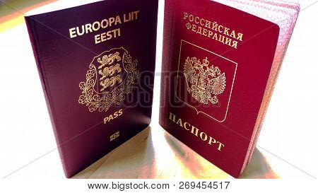 Passports On The Wooden Background. Citizenship Of Estonia And Russia. Citizenship Of European Union
