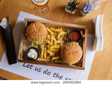 Two Mouth-watering, Delicious Burgers On The Wooden Table Small Wooden Stick Inserted In The Burgers