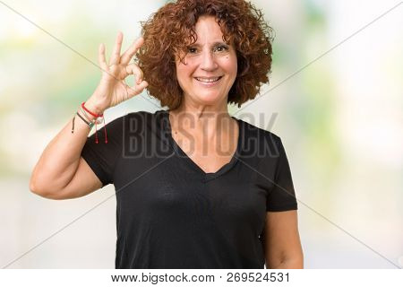 Beautiful middle ager senior woman over isolated background smiling positive doing ok sign with hand and fingers. Successful expression.