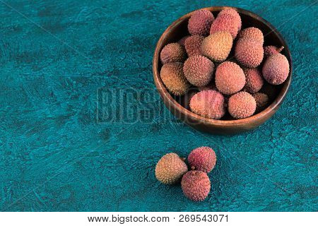 Lychee In A Wooden Bowl On A Blue Cement Background. Lychee On The Background Of Blue Cement. Turquo
