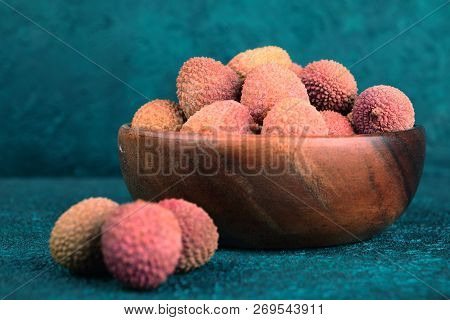 Lychee In A Wooden Bowl On A Blue Cement Background. Lychee On The Background Of Blue Cement. Turquo