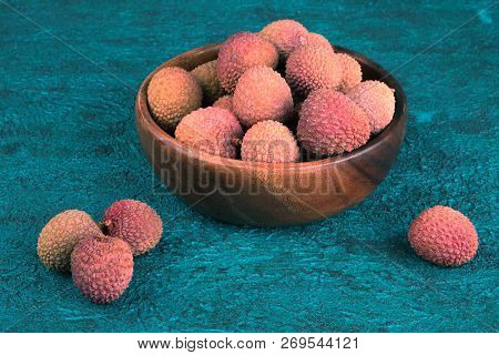 Lychee In A Wooden Bowl On A Blue Cement Background. Lychee On The Background Of Blue Cement. Turquo