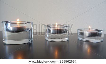Peaceful Light Emanated By Three Small Candles