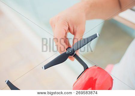 Red Drone Catching Control By Man Hands. Lays Out Propellers