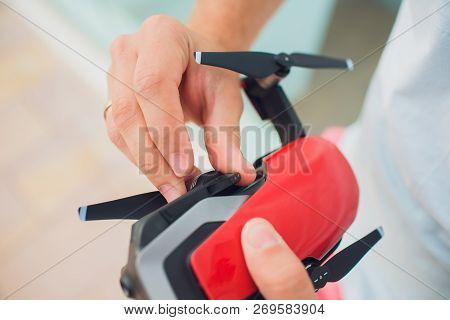 Red Drone Catching Control By Man Hands. Lays Out Propellers