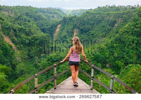 Family Vacation Lifestyle. Young Woman Stand On Edge Of Overhanging Bridge On High Cliff. Happy Girl