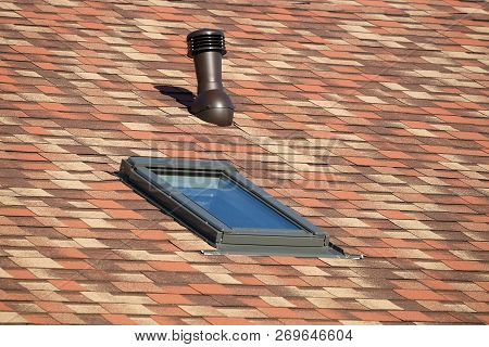 Roof Window And Ventilation Tube On Residential House Roof Covered With Motley Soft Shingles Close U