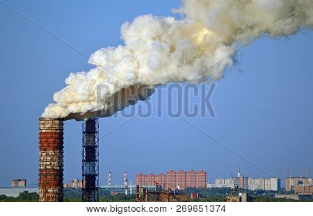Environmental Pollution. Smoke From Factory Pipes On A Background Of Clear Sky. Industrial Landscape