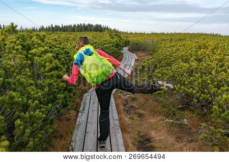 Female Hiker Dancing On Wooden Boardwalk Simply Enjoying The Nature.