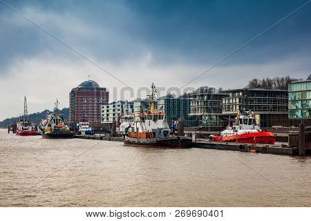 Tugboats Docked At The Hamburg Port On The Banks Of The Elbe River