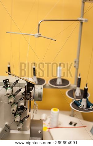 String Of Black And White Threads On White Sewing Machine On Yellow Wall