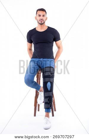 man wearing supportive leg brace in studio with white background
