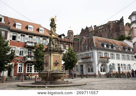 German And Foreigner Travelers People Walking And Visit Madonna Statue At The Corn Market Square In